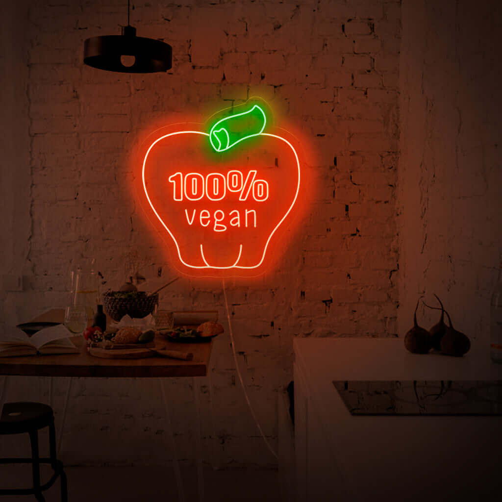"100% Vegan With Apple Neon Sign" har en levande och miljövänlig design, som stolt visar upp äppelsymbolen som ett bevis på ditt engagemang för en växtbaserad livsstil.