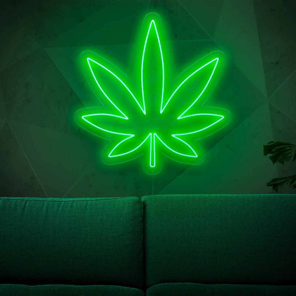 En upplyst neonskylt med ett marijuanablad som symboliserar cannabis- och ogräskultur, vilket ger en touch av örtcharm till alla utrymmen