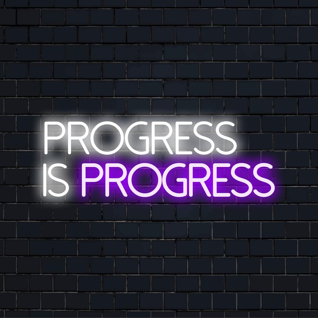 Anpassad LED neonskylt med texten Progress Is Progress i livfulla färger, perfekt för modern inredning och inspiration.