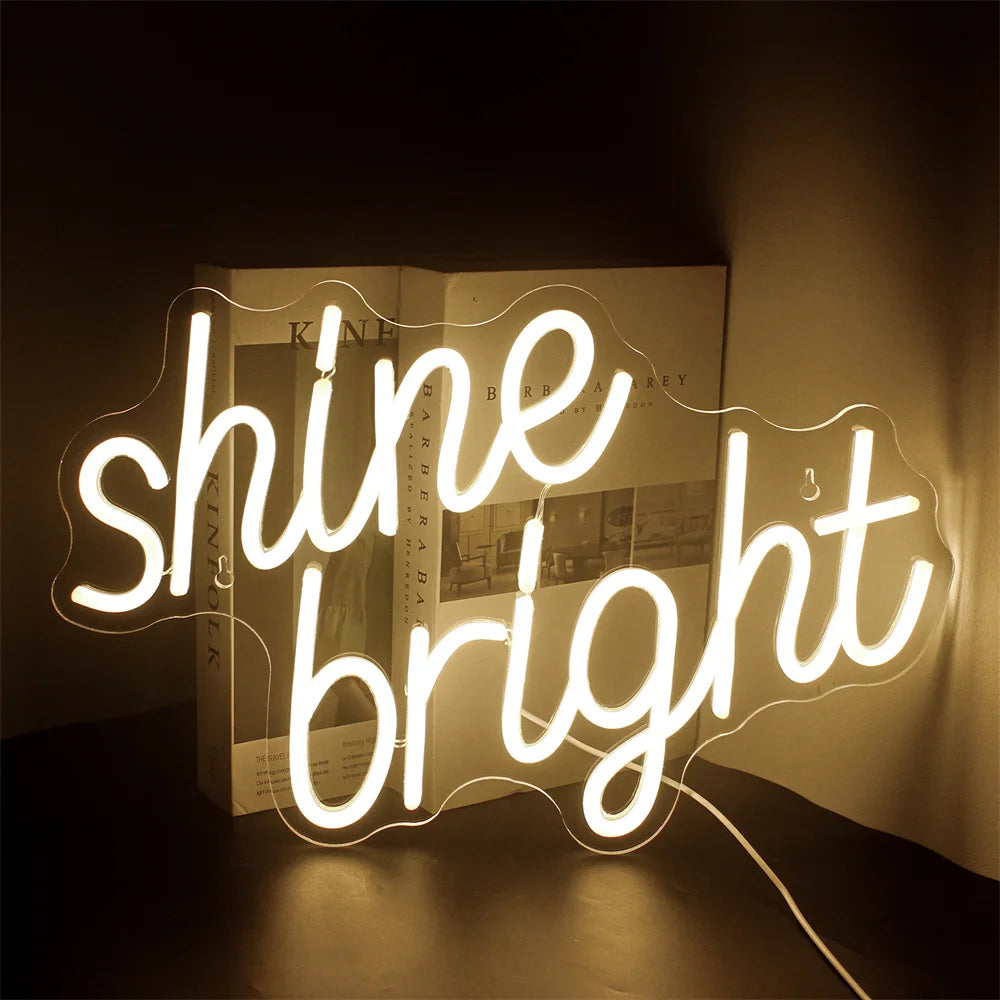 En livlig LED-neonskylt som visar orden "Shine Bright" i ett livligt manustypsnitt.