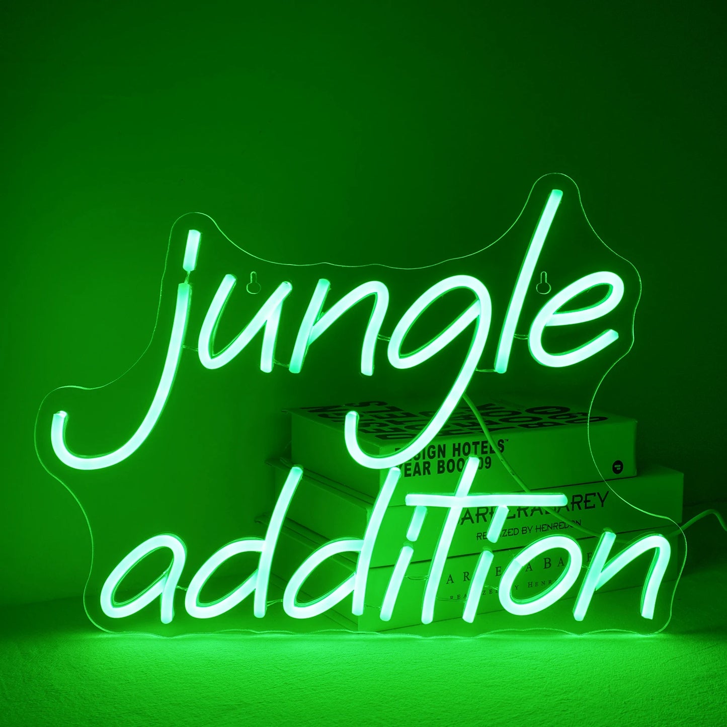 En livlig grön "Jungle Addition" LED neonskylt, mot en minimalistisk vit väggbakgrund.