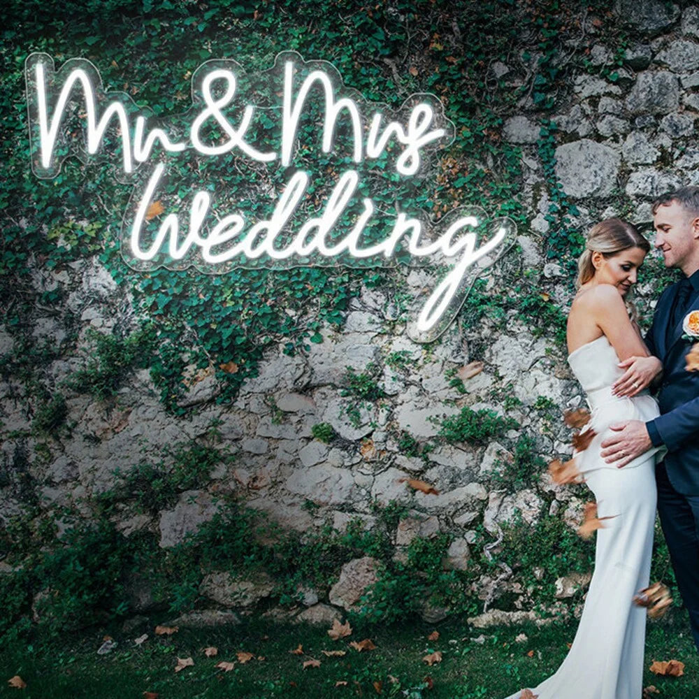 Bilden visar en elegant LED-neonskylt som lyser med orden "Mr & Mrs" i ett elegant kursivt teckensnitt.