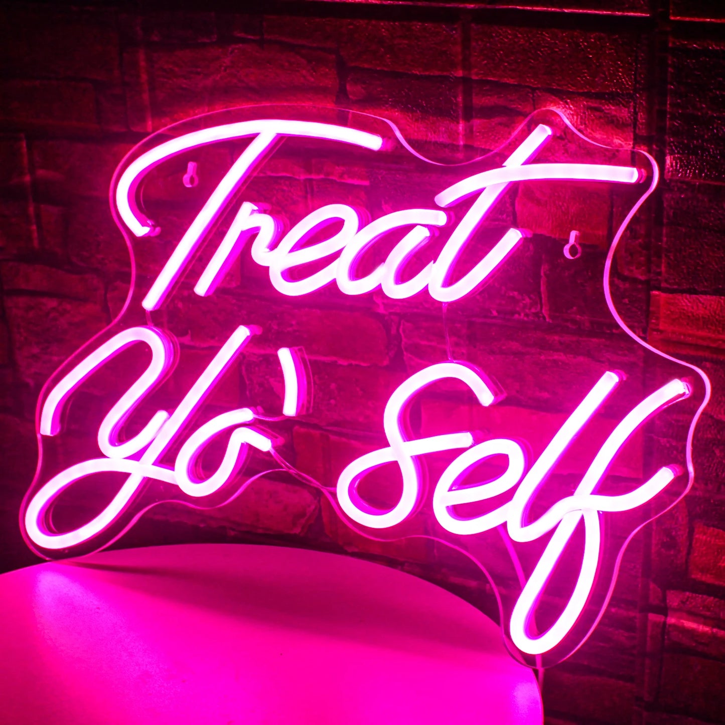 Bilden har en levande LED-neonskylt som visar orden "Treat Yo' Self" i ett elegant, kursivt teckensnitt.