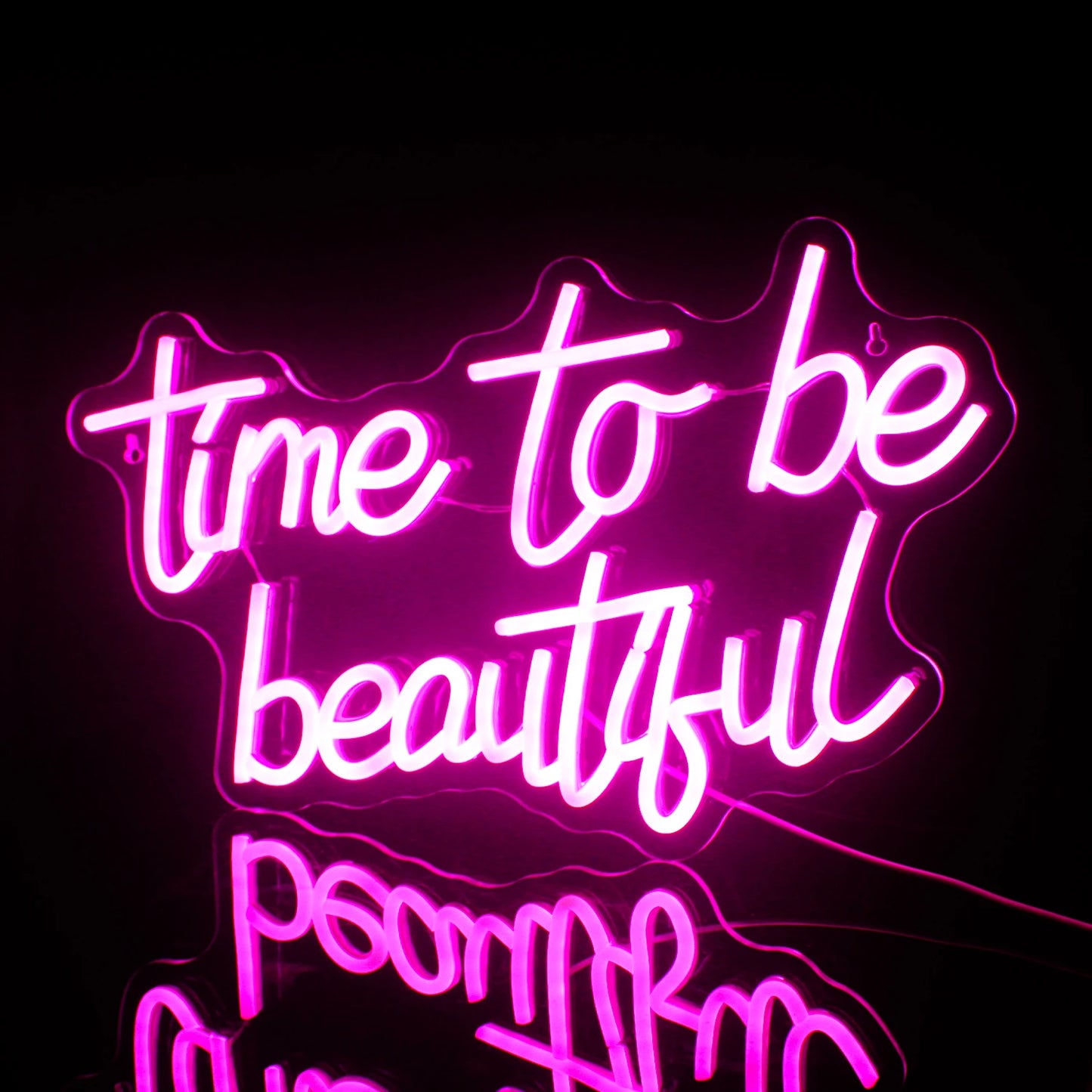 En livlig "Time to be Beautiful" LED-neonskylt som visas mot en minimalistisk mörkgrå vägg.