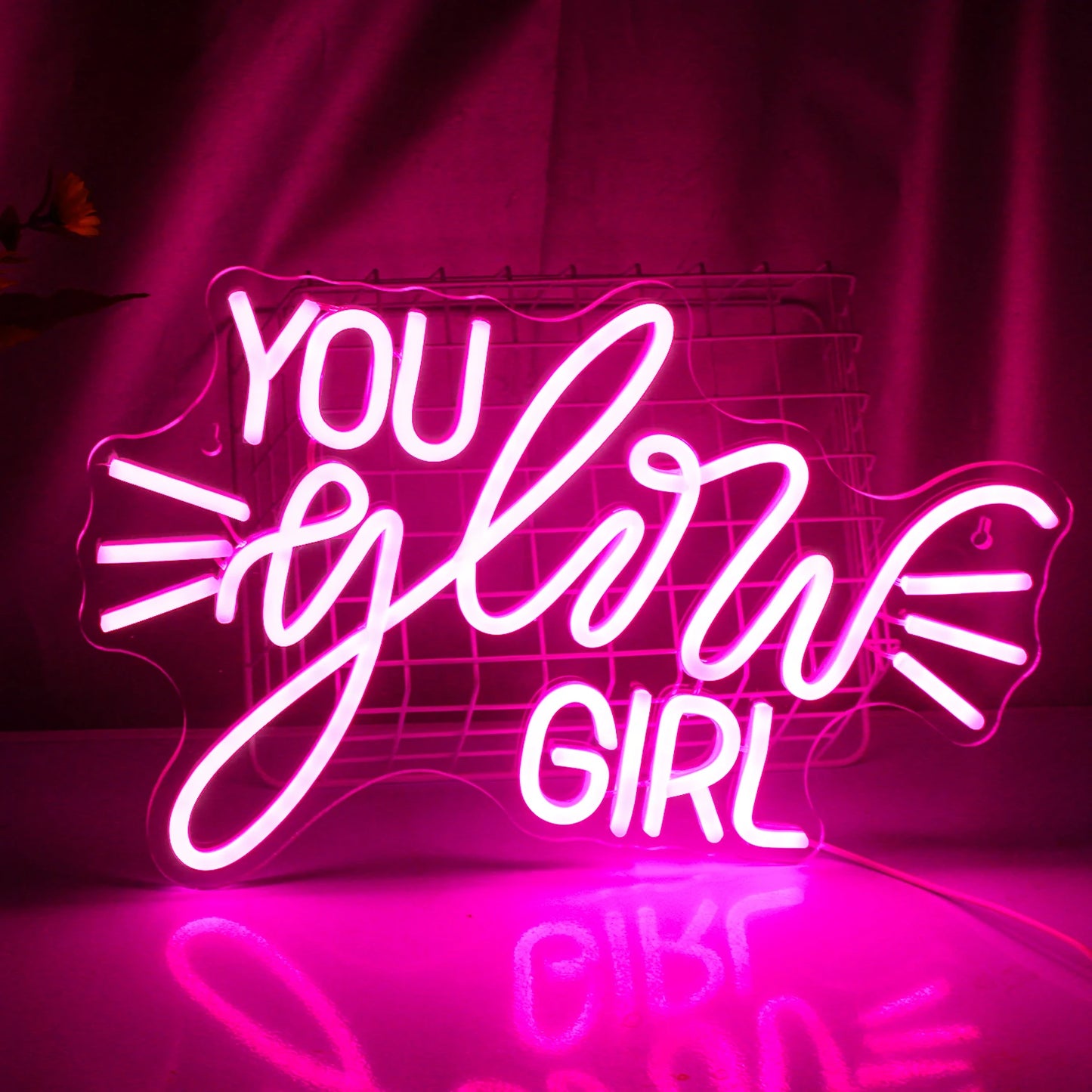 Bilden har en levande LED-neonskylt som läser "You Glow Girl" i ett stilfullt kursivt teckensnitt.