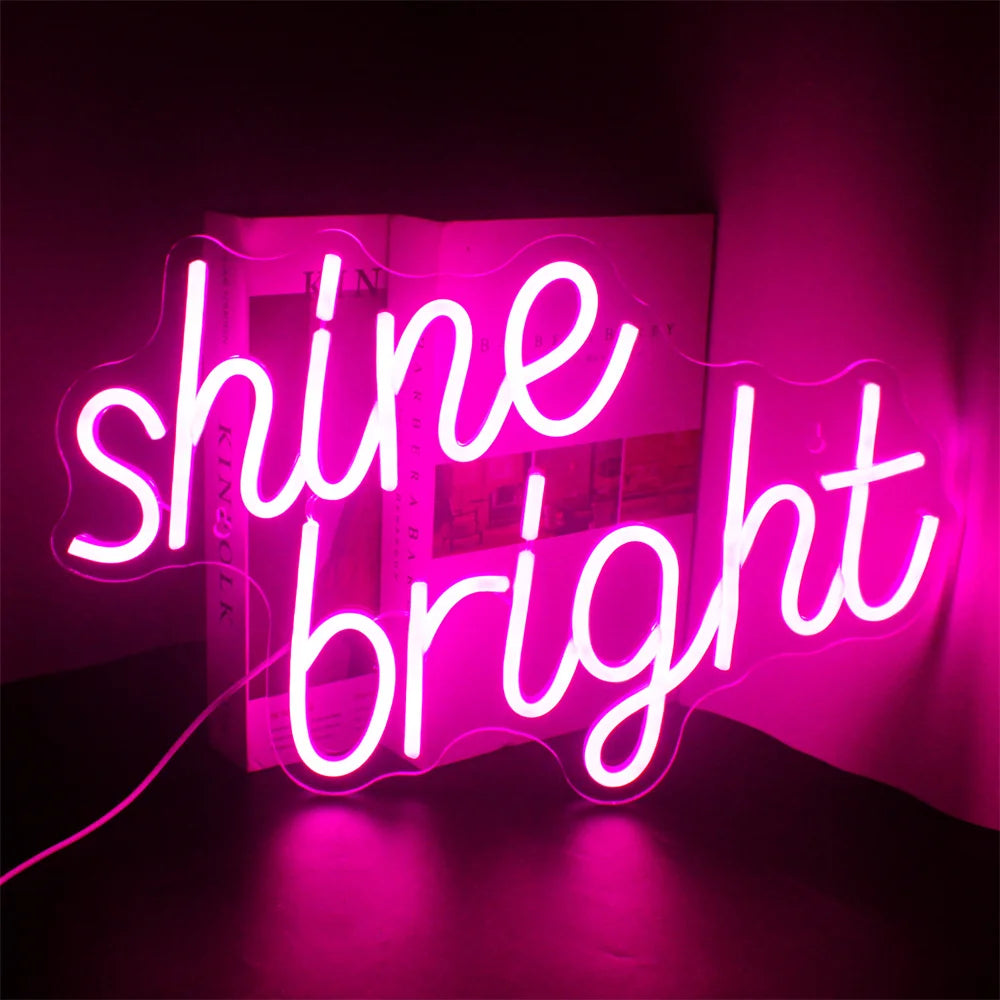 Bilden visar upp en levande och elegant LED-neonskylt som läser "Shine Bright" i elegant, kursiv handstil.