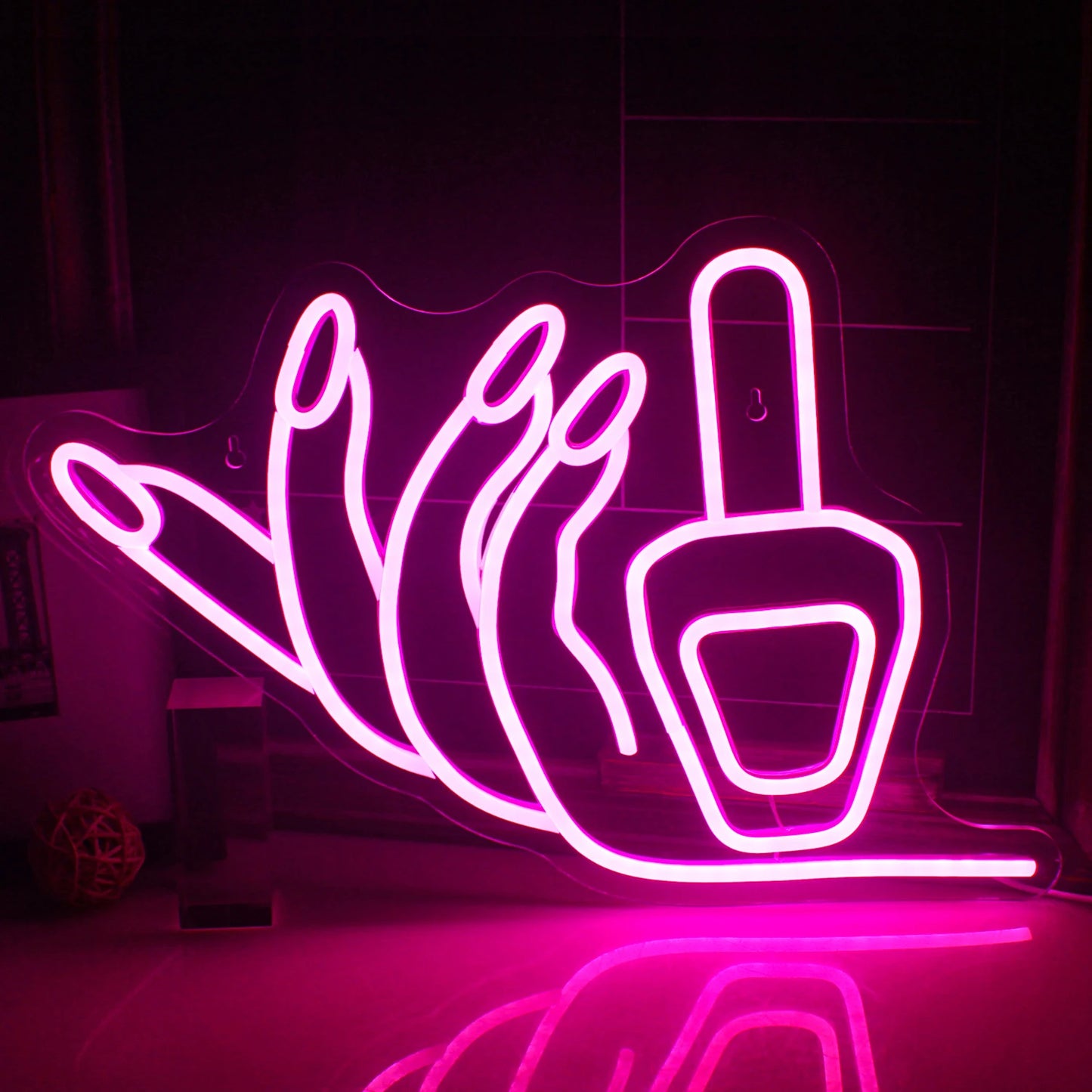 Bilden visar en levande, handgjord LED-neonskylt i form av en nagel, glödande i ljust rosa.