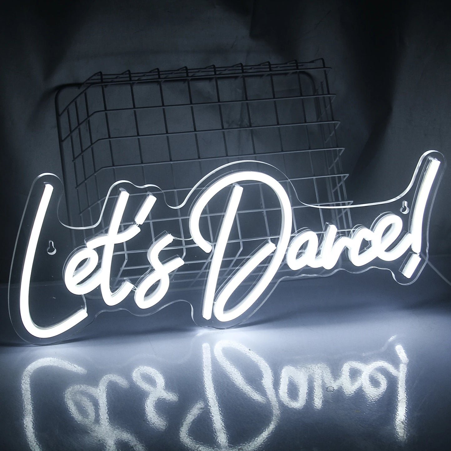 En starkt upplyst "Let's Dance" LED-neonskylt i livfulla rosa och blå färger.