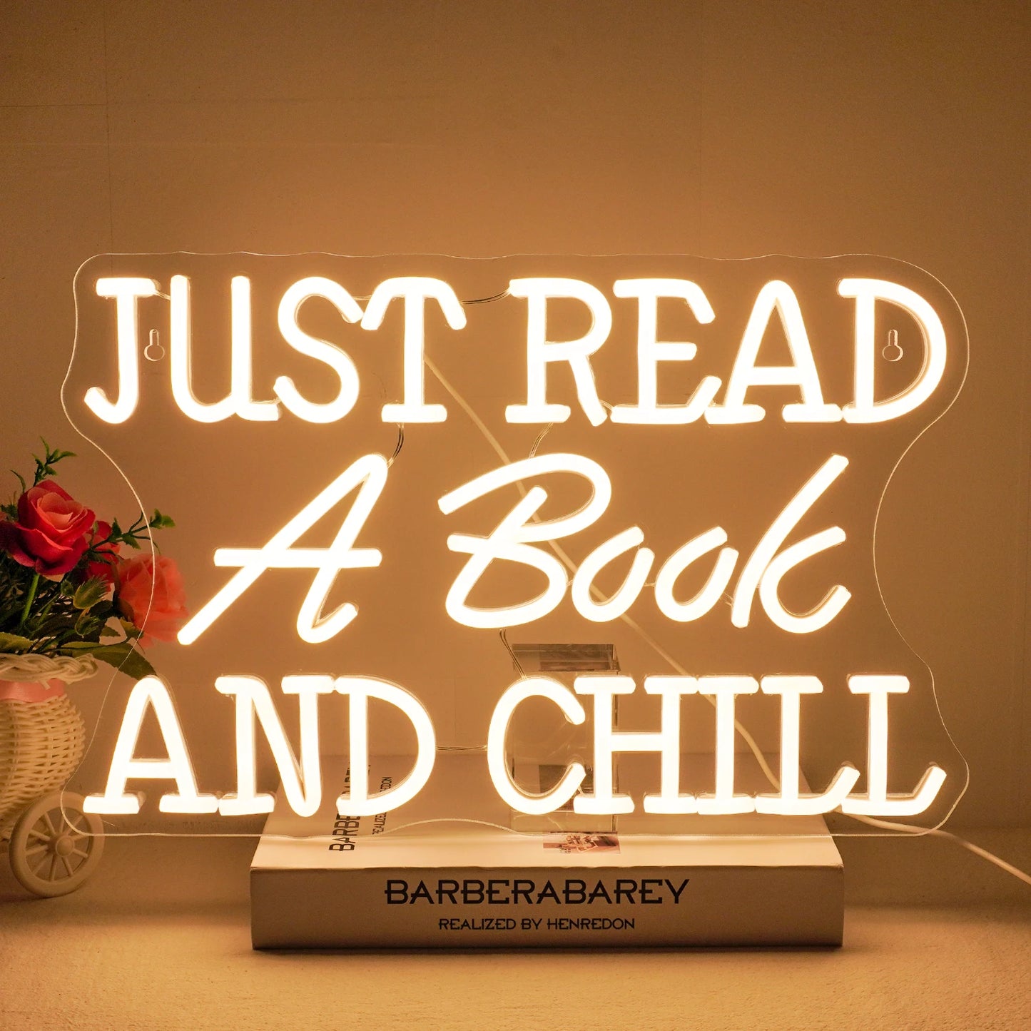 Bilden har en levande LED-neonskylt som stavar ut frasen "Just Read A Book And Chill.