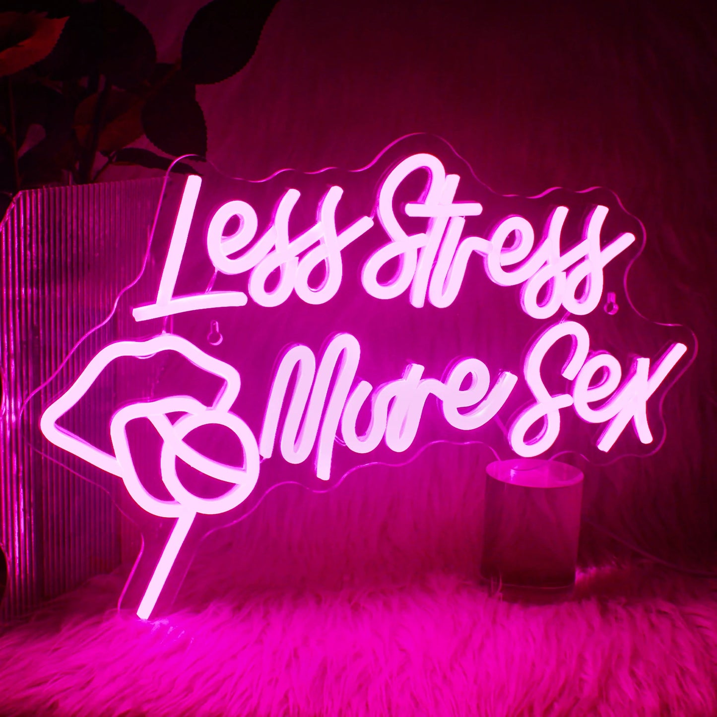 En levande LED-neonskylt som visar frasen "Less Stress More Sex" i ett elegant, kursivt teckensnitt.