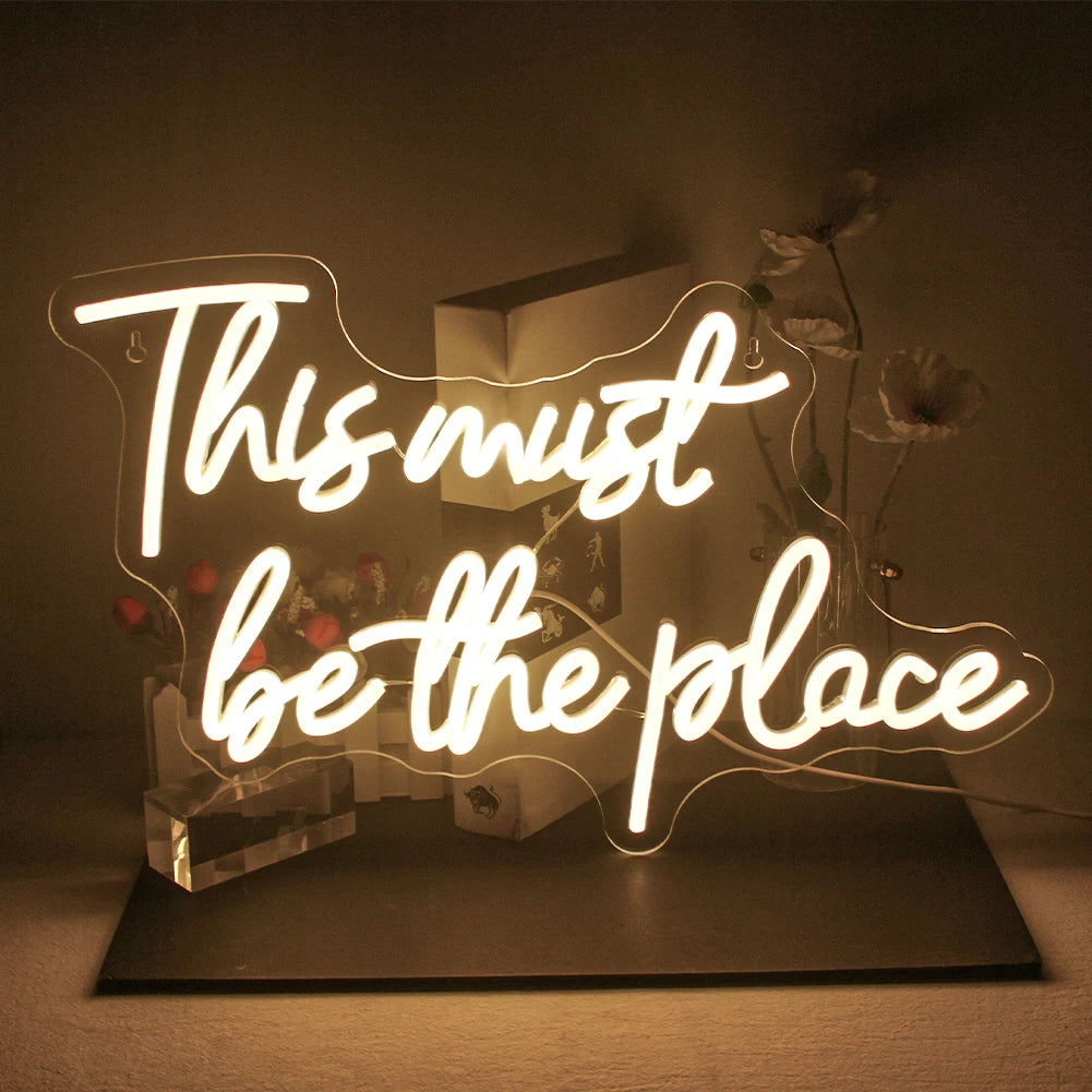 Bilden visar en levande LED-neonskylt som läser "This must be the place" i kursiv skrift.