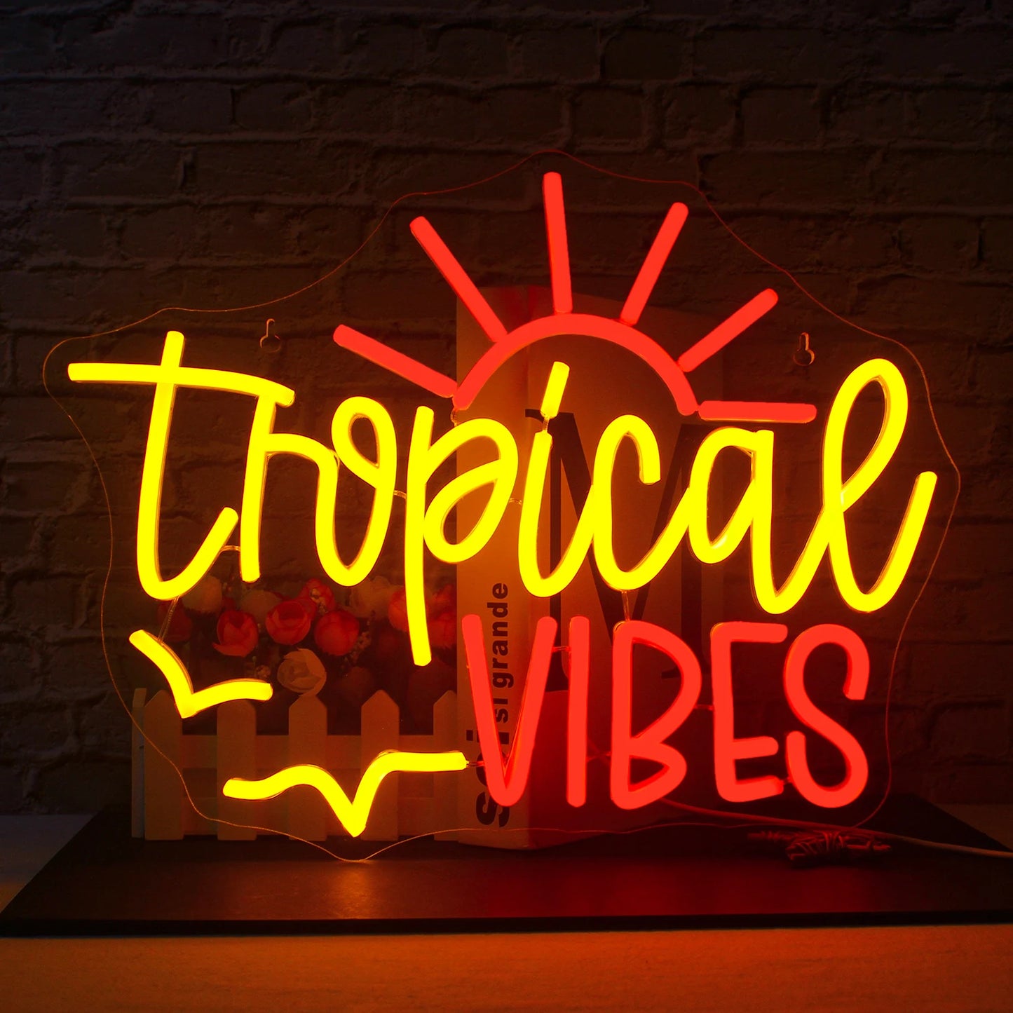 En bild som visar upp en glödande LED-neonskylt som stavar ut "Tropical Vibes" i livfulla färger.