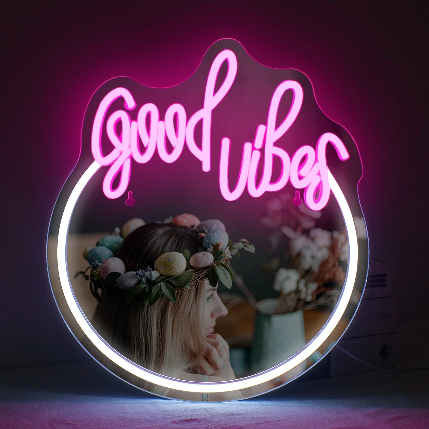 Bilden visar en elegant LED-neonskylt som stavar "Good Vibes" med livfulla, lysande rosa bokstäver.