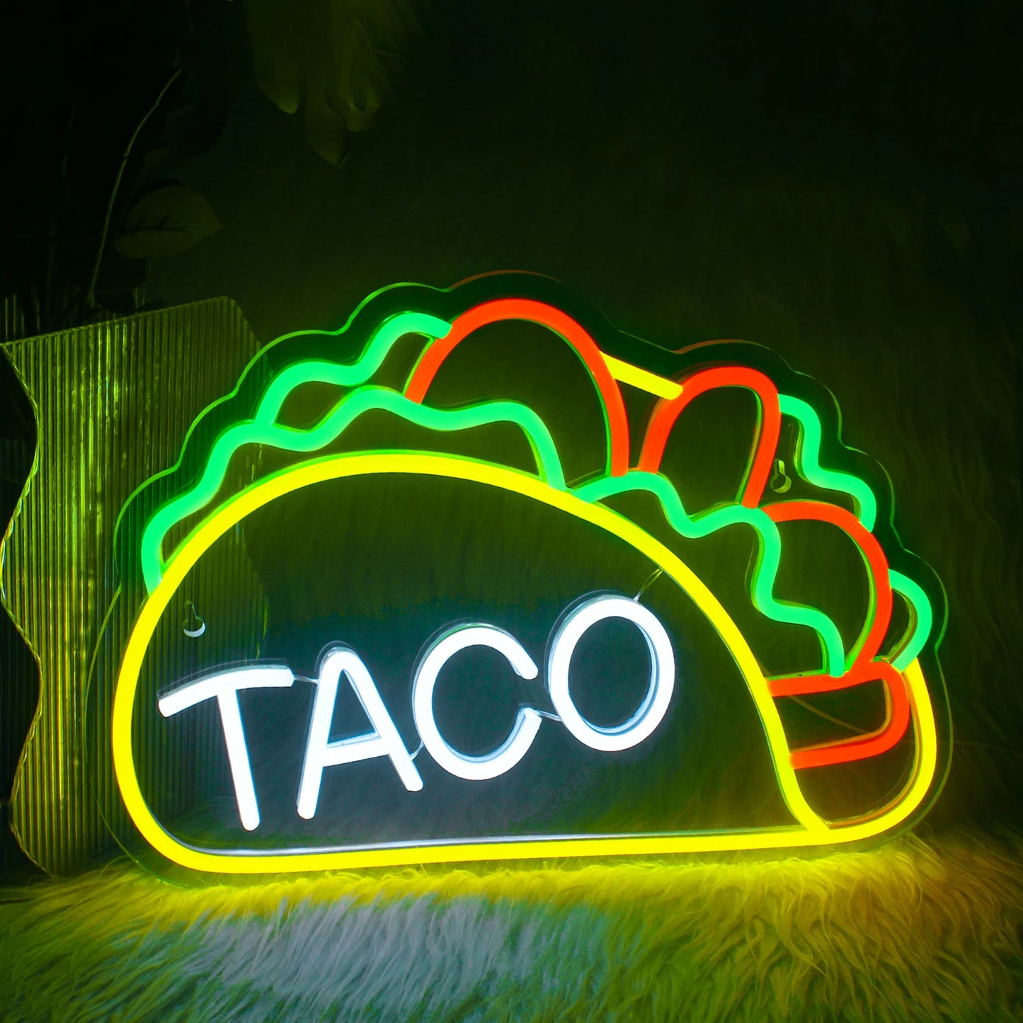Bilden har en levande LED neonskylt formad för att stava ordet "Tacos.