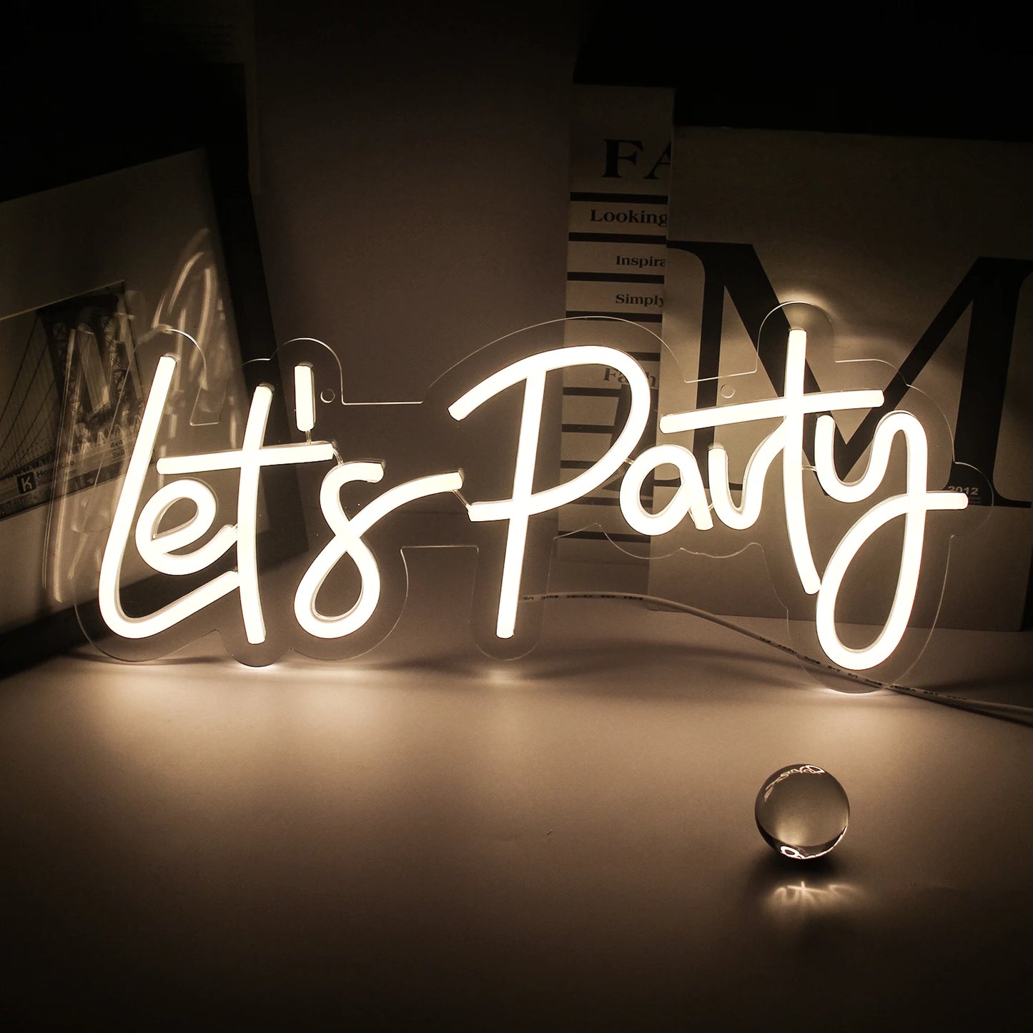 En livlig "Let's Party" LED-neonskylt visas, med djärva, kursiva bokstäver.