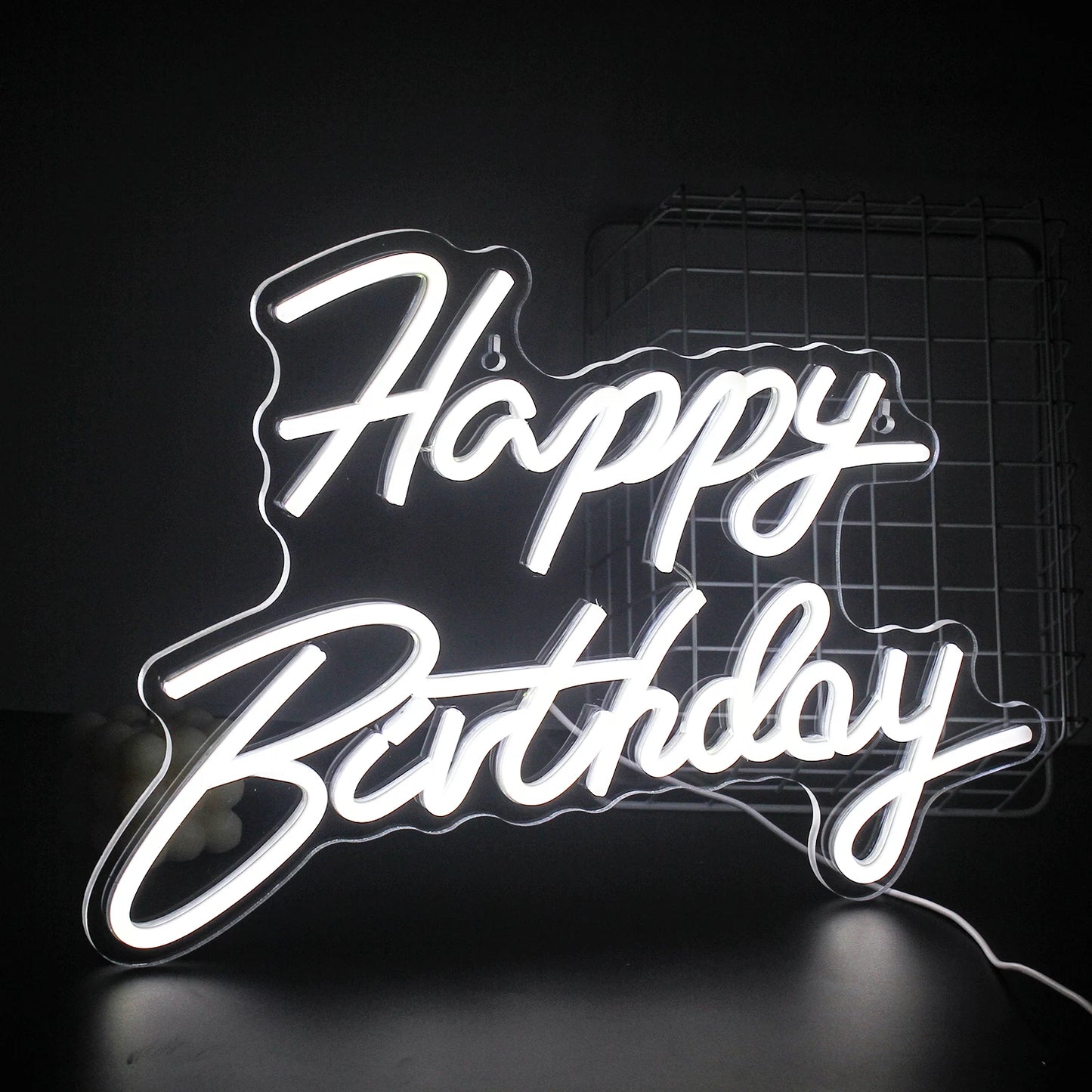 En livlig "Happy Birthday" LED neonskylt som lyser varmt mot en mörk bakgrund.