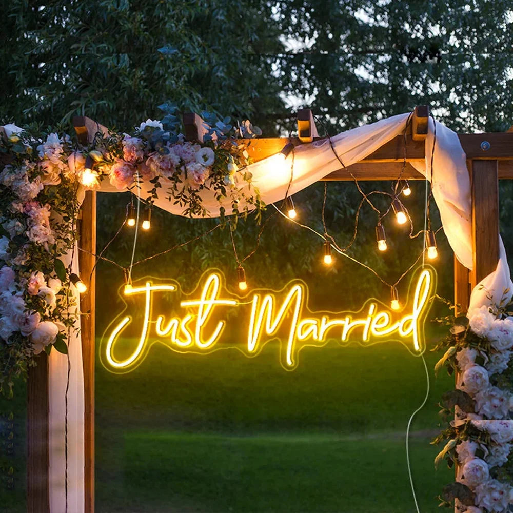 En glödande LED-neonskylt som visar orden "Just Married" i elegant, kursivt manus.