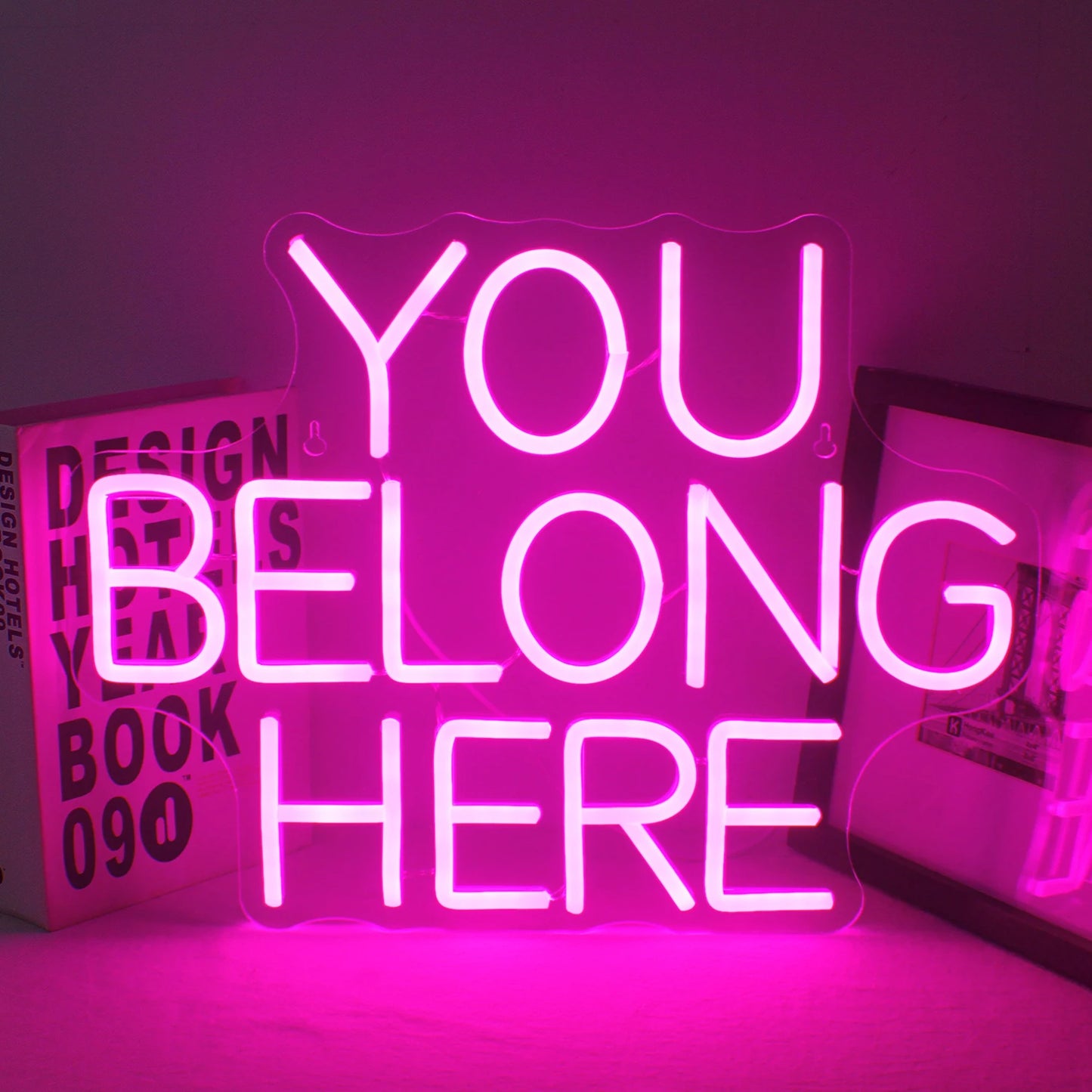 En levande LED-neonskylt som visar orden "You Belong Here" i ett varmt, inbjudande manustypsnitt.