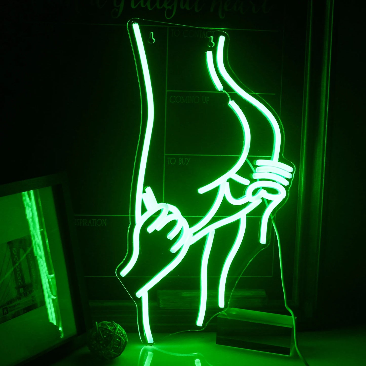 Bilden har en levande LED-neonskylt i form av en siluett som föreställer en sensuell, kurvig figur av en kvinna.