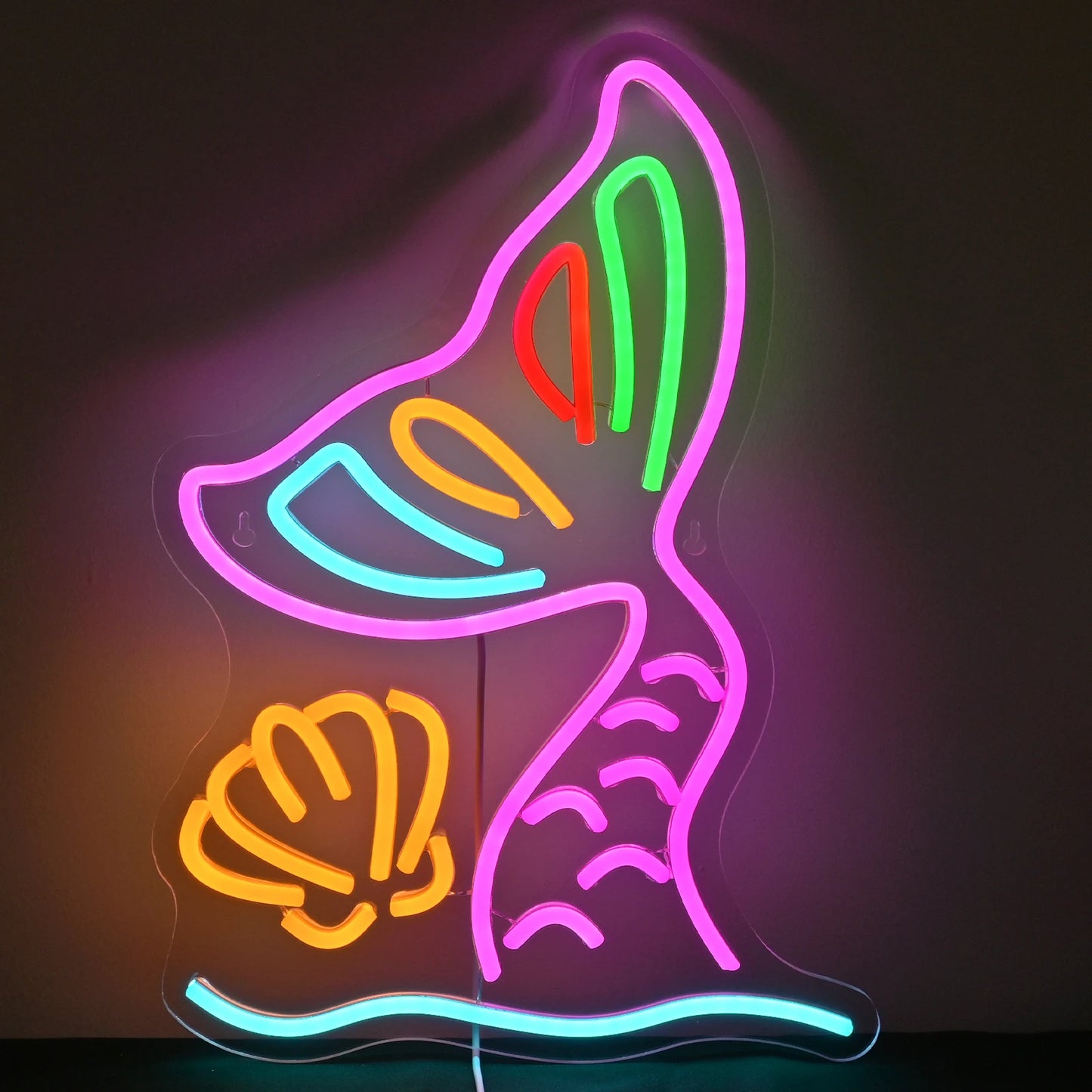 Bilden har en levande LED-neonskylt i form av en sjöjungfrusvans.