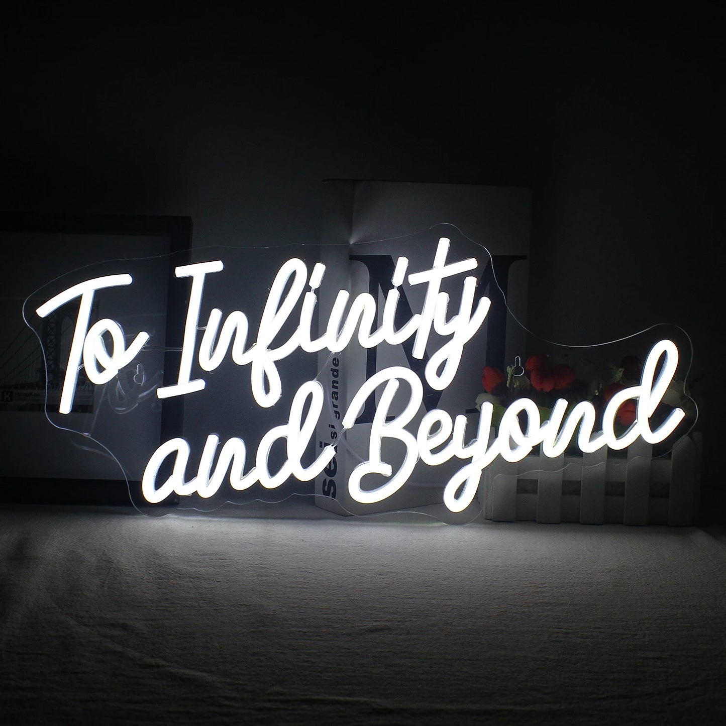 Bilden visar en handgjord LED-neonskylt där det står "To Infinity and Beyond" med livfulla, glödande bokstäver.