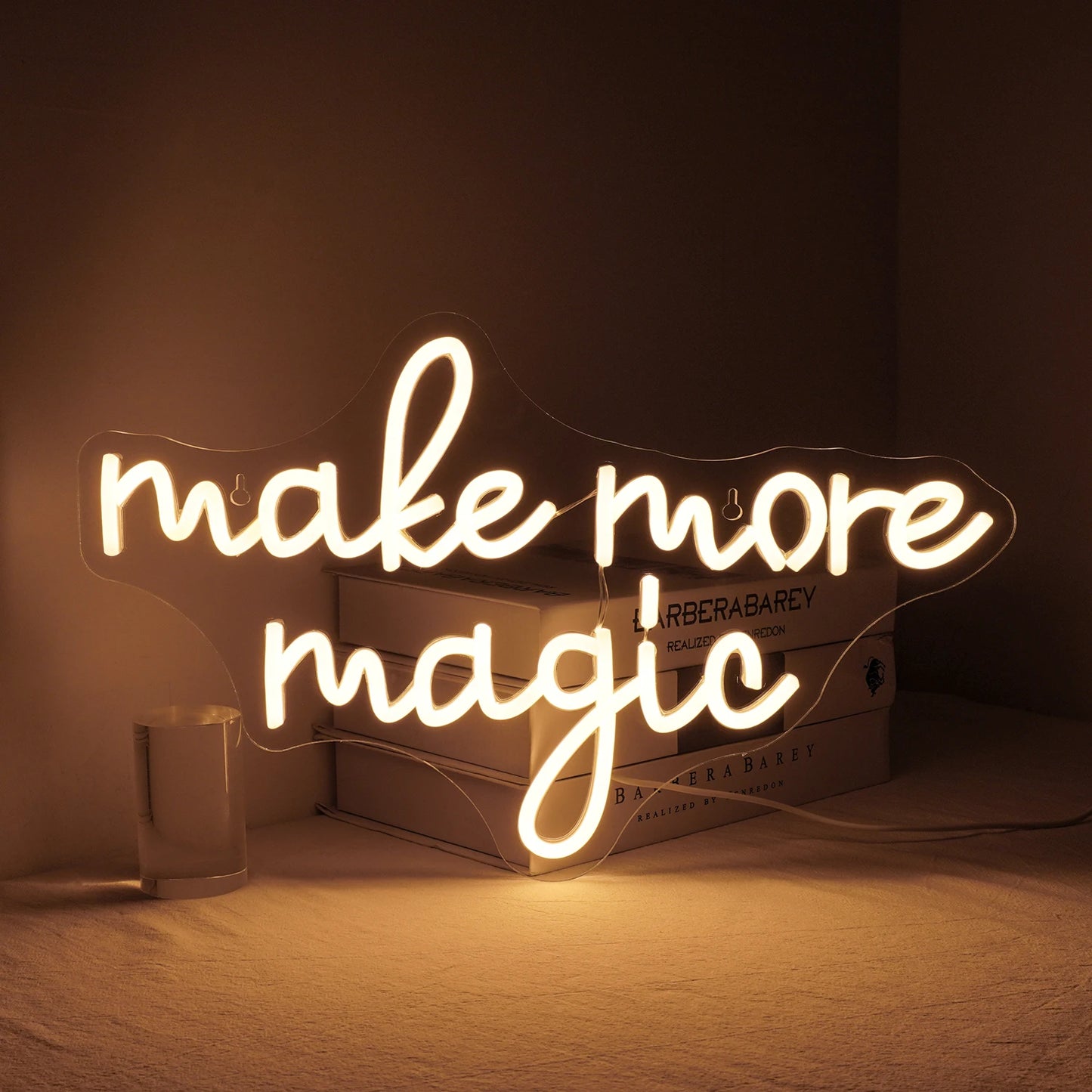 En livlig "Make More Magic" LED-neonskylt i en livlig blandning av färger är monterad mot en elegant, mörk bakgrund.