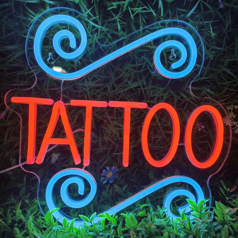En upplyst LED-neonskylt stavar ordet "TATUERING" med fetstil, versaler.