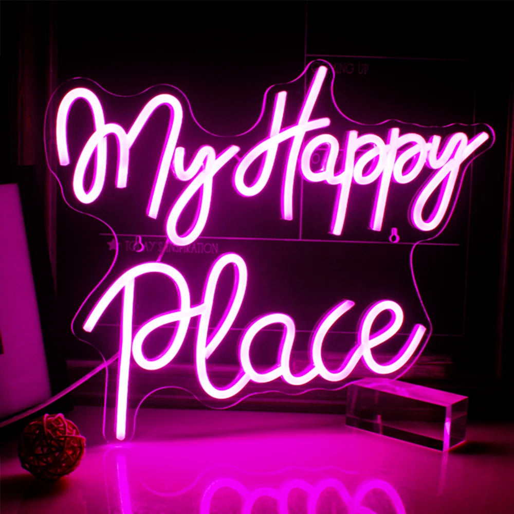 En livlig "My Happy Place" LED-neonskylt visas tydligt på en vägg och ger ett varmt och inbjudande sken.