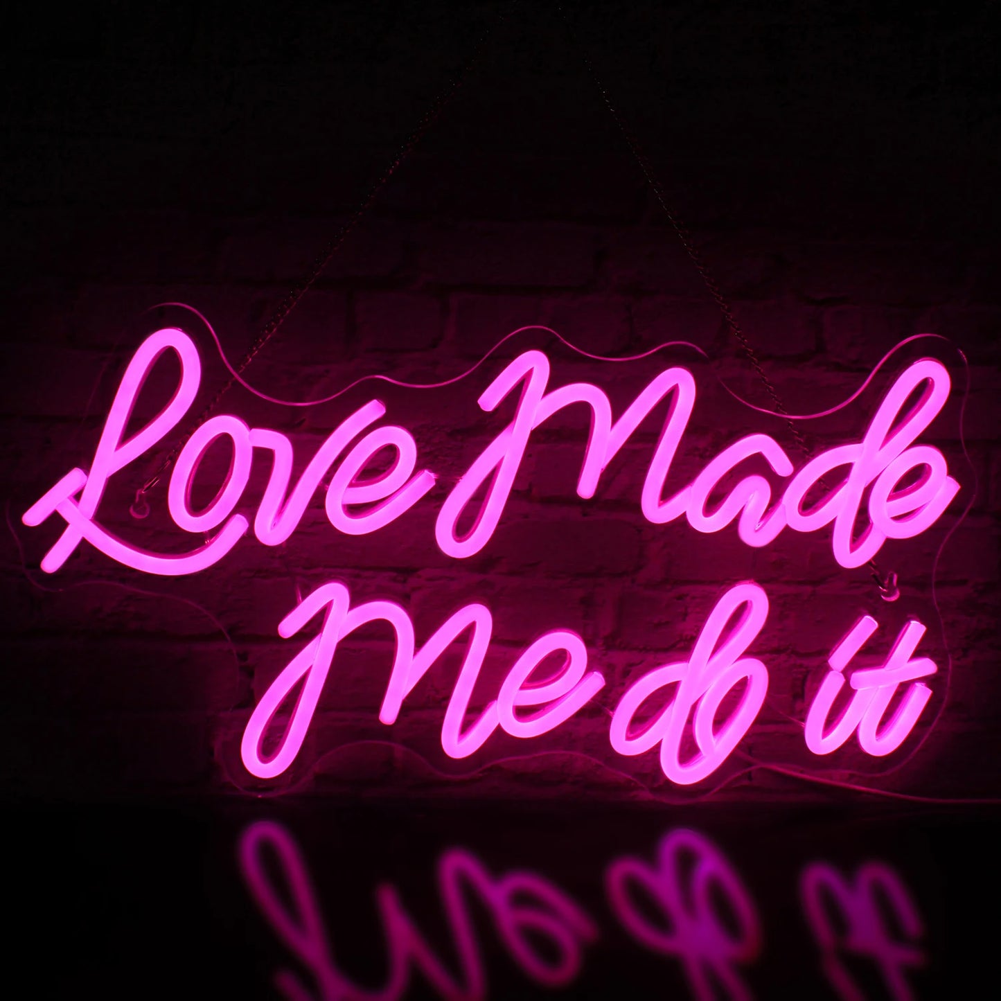 Bilden har en levande LED-neonskylt som visar orden "Love Made Me Do It" i en stilig kursiv stilsort.