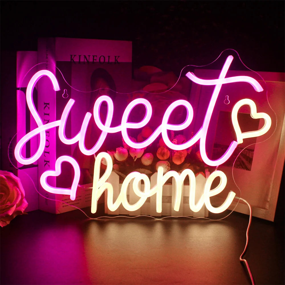 Bilden har en levande, handgjord LED-neonskylt som visar orden "Sweet Home" i ett elegant, kursivt manus.