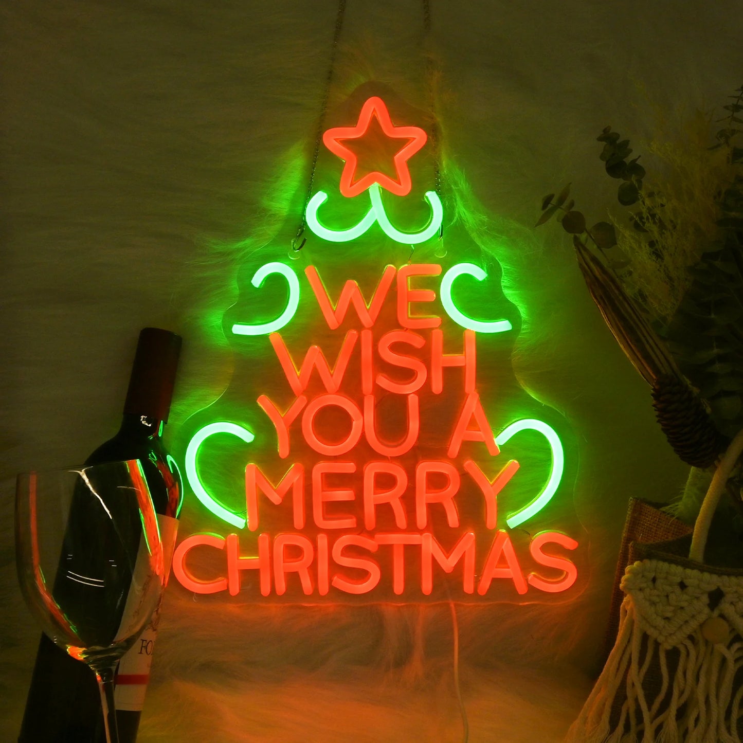 Bilden har en levande LED-neonskylt som visar orden "Vi önskar dig en god jul" i en festlig, kursiv stilsort.