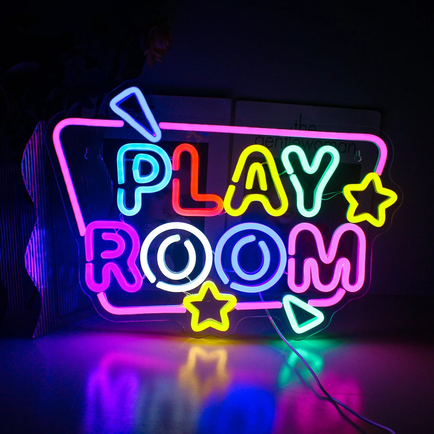 Bilden har en levande LED-neonskylt som läser "Play Room" i ljusa, lekfulla färger.