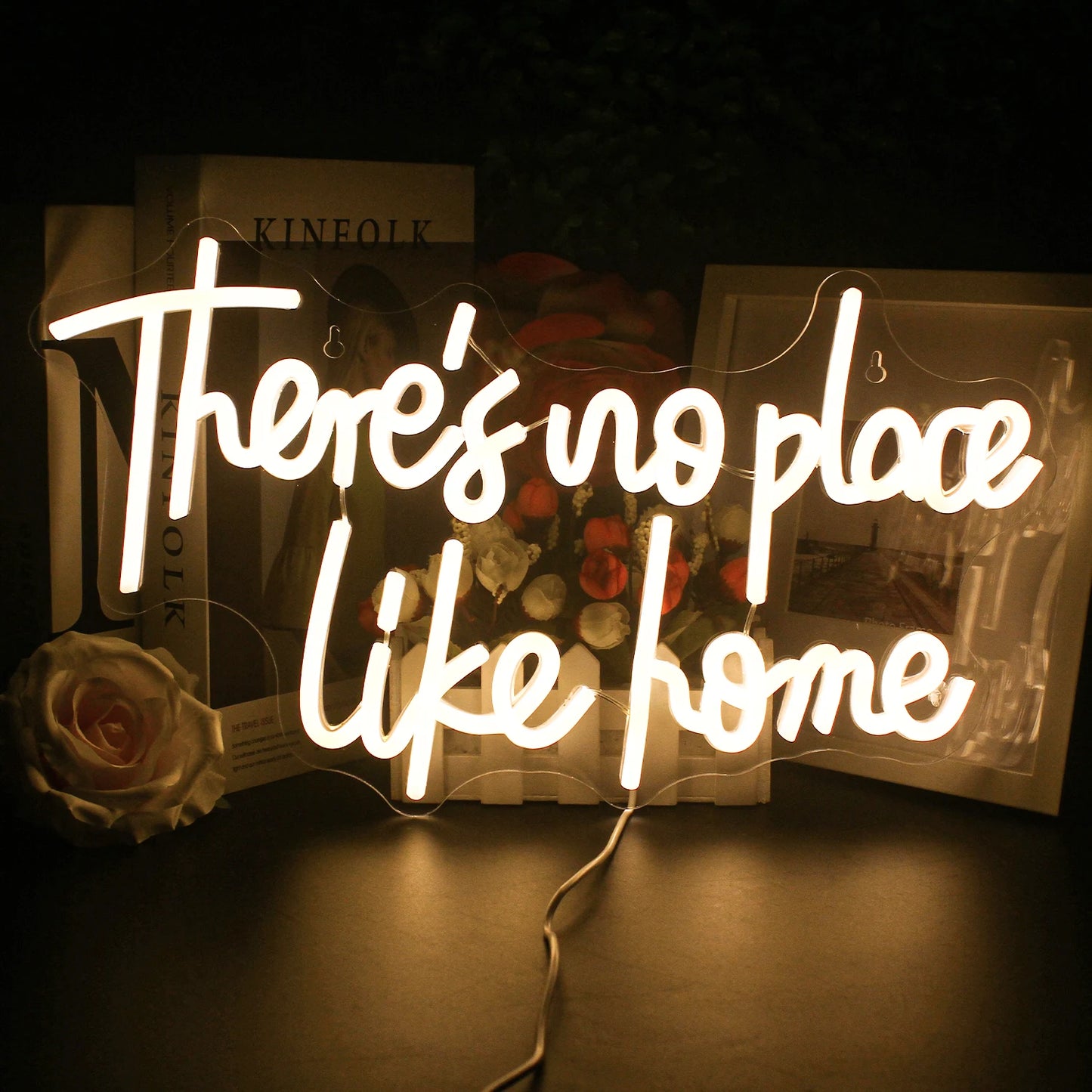 Bilden har en elegant och livfull LED-neonskylt som visar frasen "There's No Place Like Home.