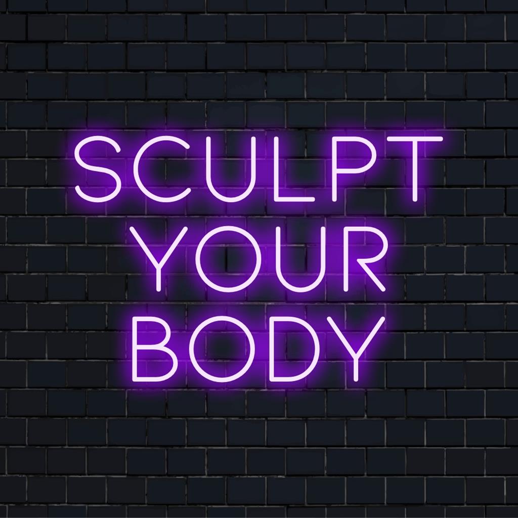 Anpassad LED-neonskylt med den motiverande frasen "Sculpt Your Body" glödande i livfulla nyanser, inspirerande fitnessfokuserad inredning.