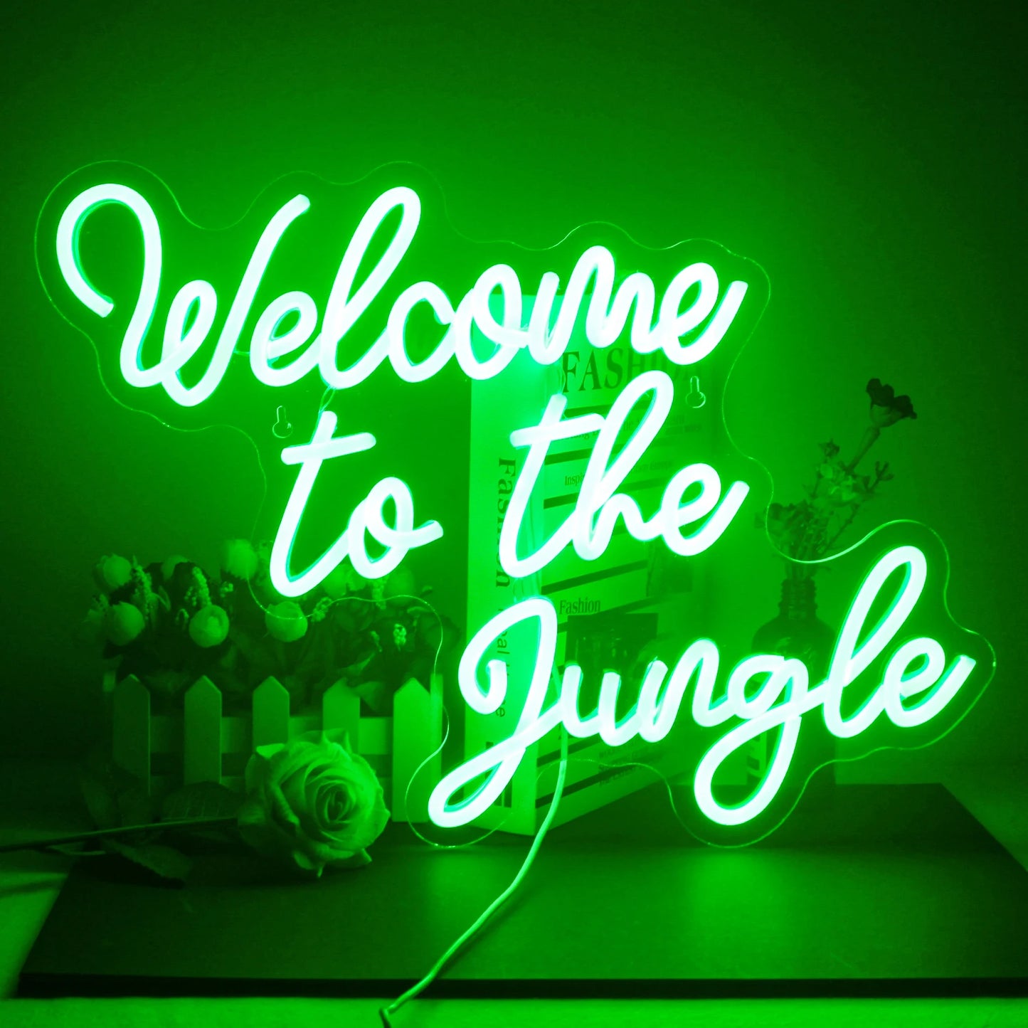 En levande LED-neonskylt som läser "Welcome To The Jungle" i djärvt, lekfullt manus.