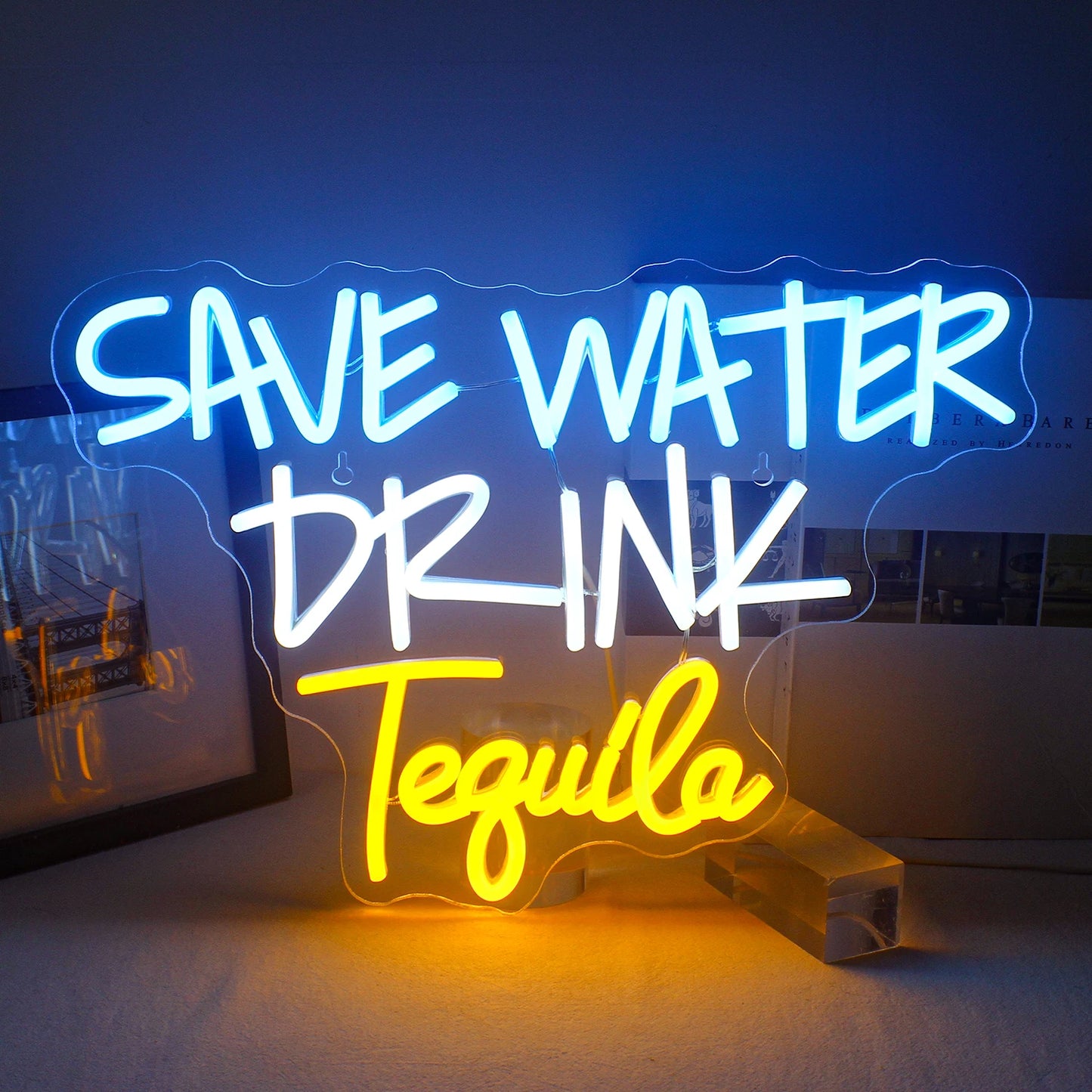 Bilden har en levande LED-neonskylt som visar frasen "Spara vattendryck Tequila" i fet, lekfull typografi.