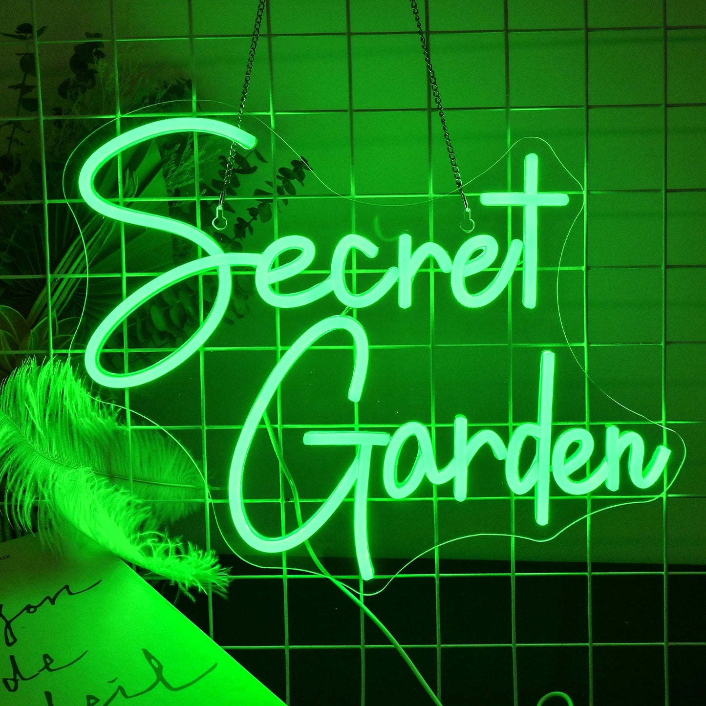 En livlig LED-neonskylt med orden "Secret Garden" med eleganta, kursiva bokstäver.