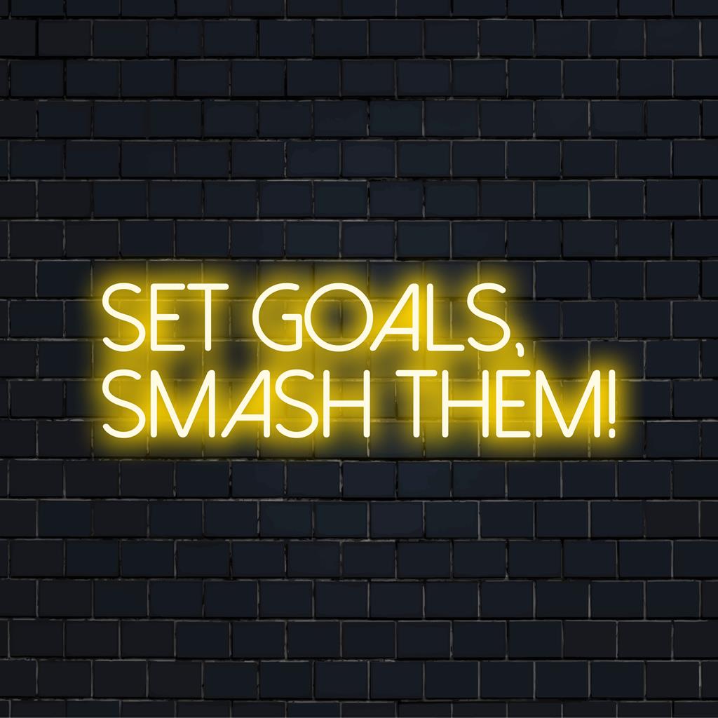 Sätt upp mål, krossa dem! i djärvt LED-ljus. Idealisk neondekor för motivation, med ljusa och stärkande ord.