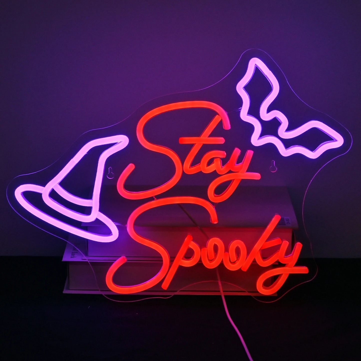 Bilden har en handgjord LED-neonskylt som visar orden "Stay Spooky" i ett lekfullt, flytande manus.