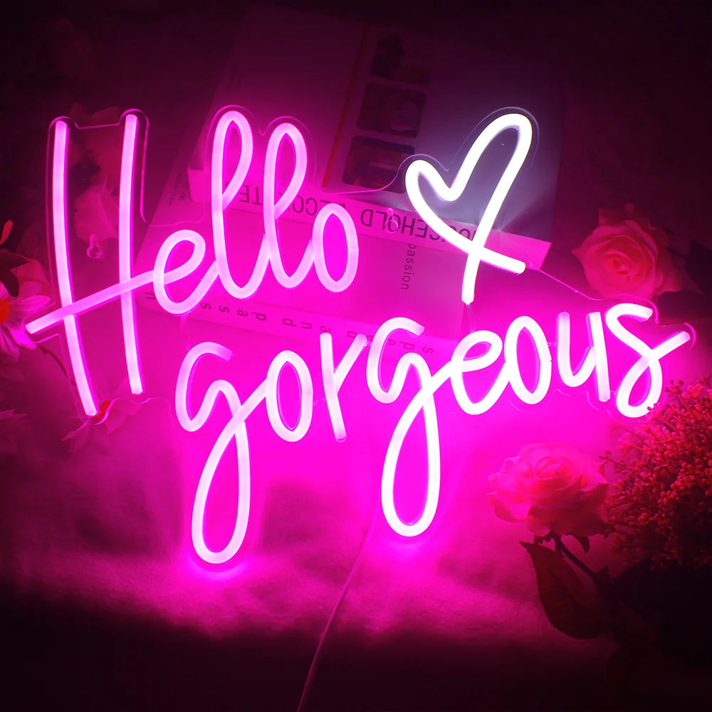 Bilden har en handgjord LED-neonskylt som visar orden "Hello Gorgeous" i elegant, kursivt manus.