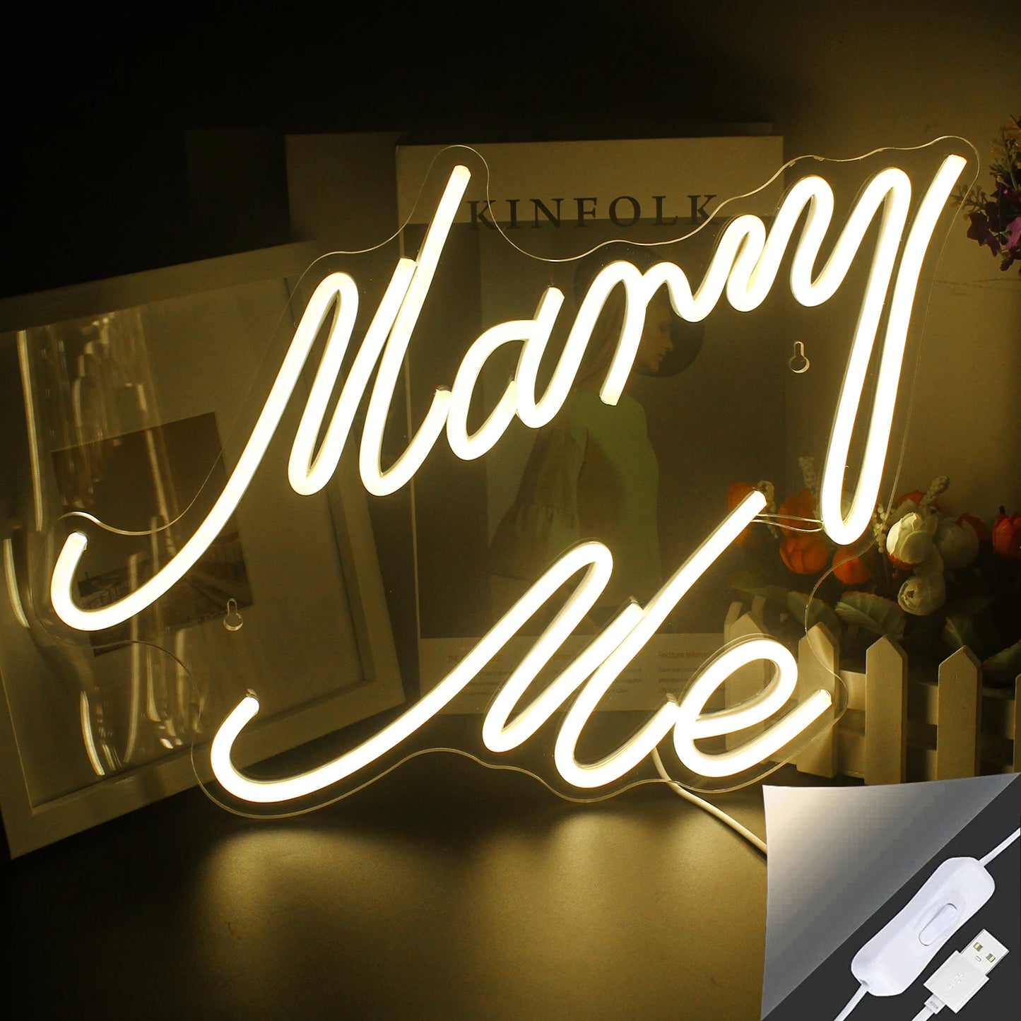 En "Marry Me" LED neonskylt visas, lyser starkt i en varmvit nyans.