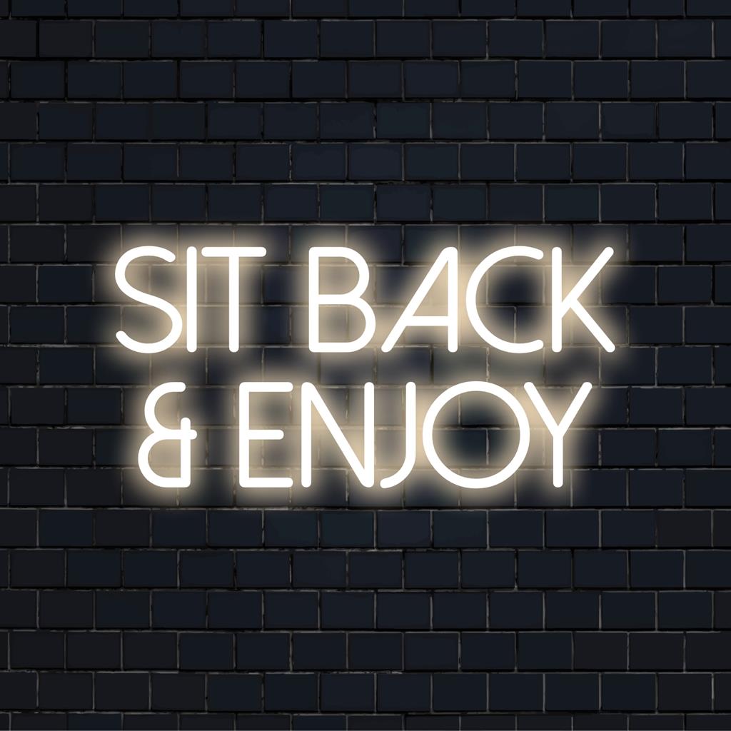 Anpassad LED-neonskylt som läser Sit Back And Enjoy i ljusa nyanser, perfekt för att förbättra avkopplingsutrymmen och loungeområden.