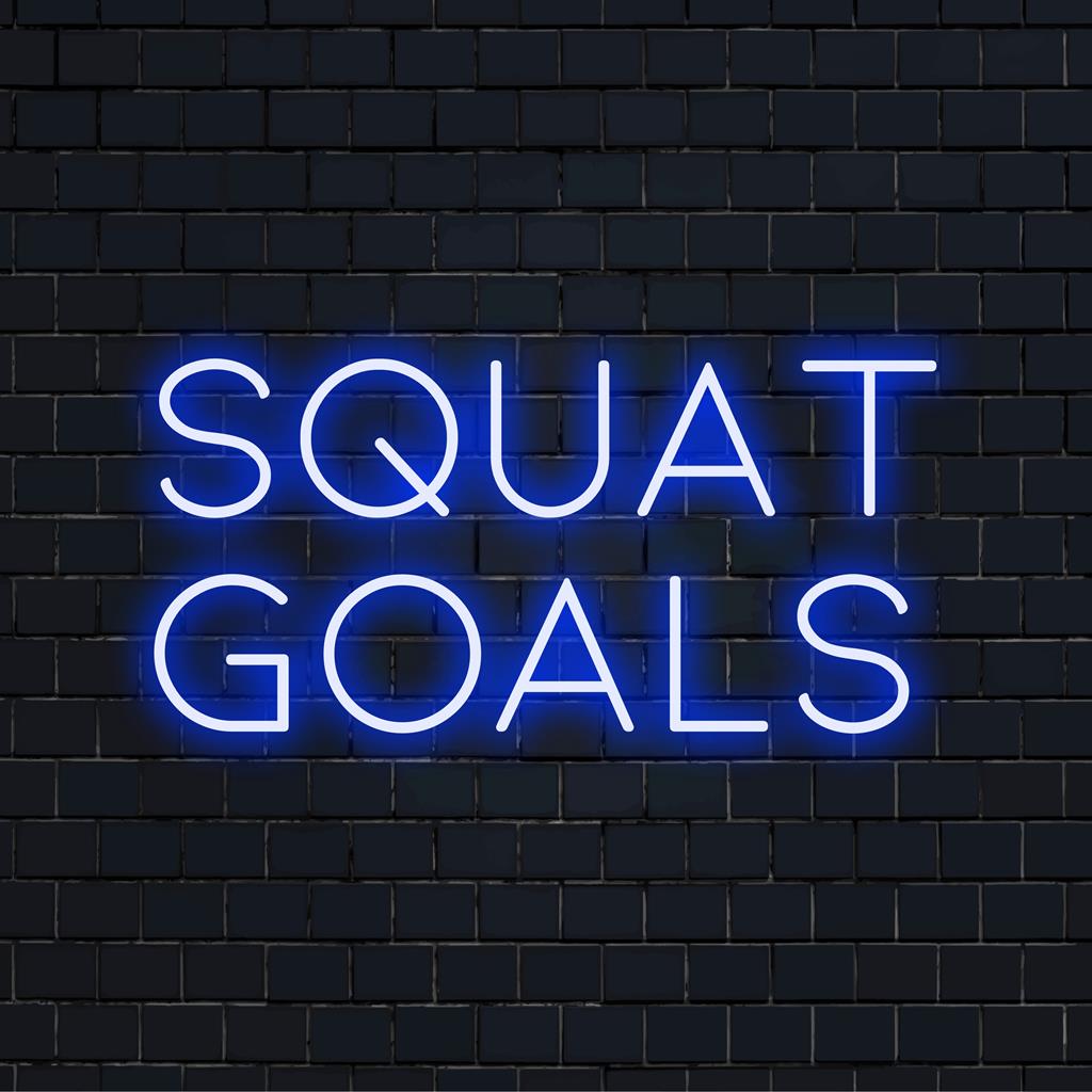 Anpassad LED neonskylt som läser Squat Goals upplyst i levande ljus, perfekt för gyminredning eller motiverande väggkonst.