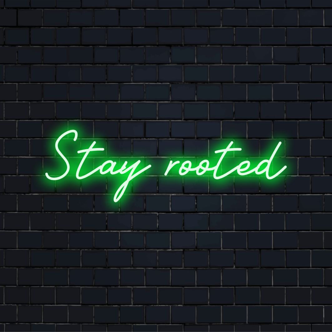 Vibrant Stay Rooted anpassad LED-neonskylt glödande i vitt, perfekt som personlig neonheminredning eller slående väggkonst.