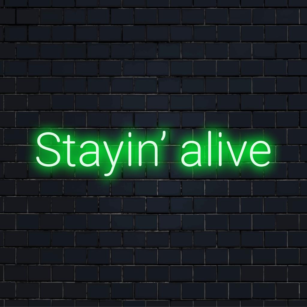 Skräddarsydd LED-neonskylt med den ikoniska frasen Stayin' Alive, perfekt för livfull neoninredning för hem eller kontor.