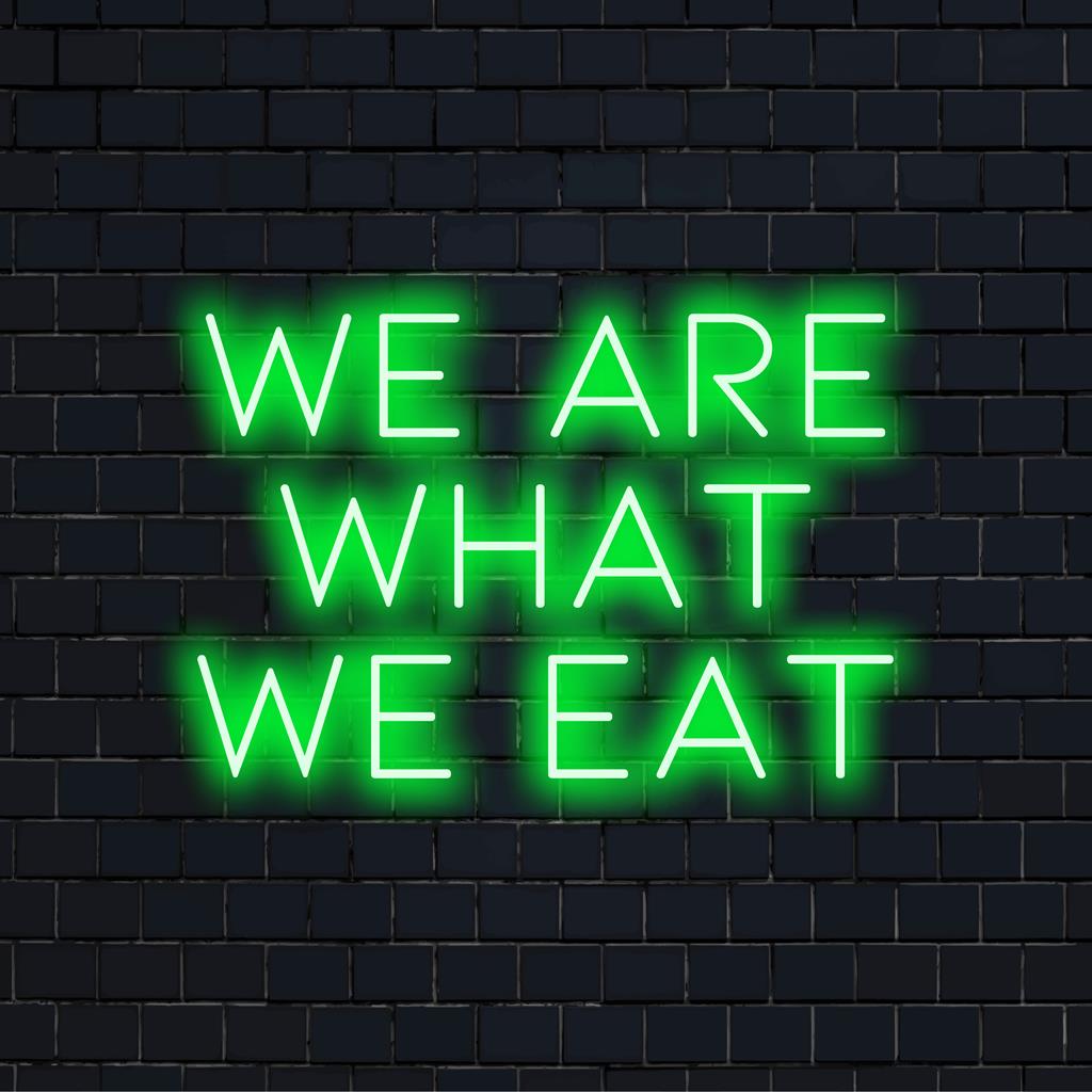 LED-neonskylt som visar We Are What We Eat och visar ljusa estetiska neonljuskonst perfekt för modern inredning.