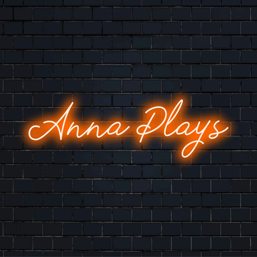 Anna Plays Personalized Neon Light with neon text light against black brick wall
