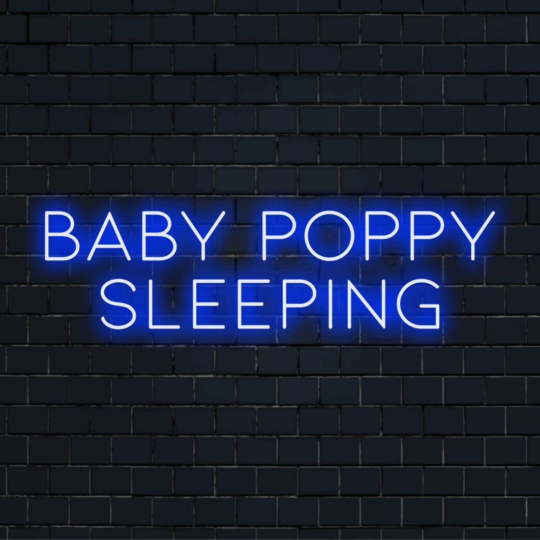 Baby Poppy Sleeping Custom Name Neon Sign, glowing lettering against brick backdrop