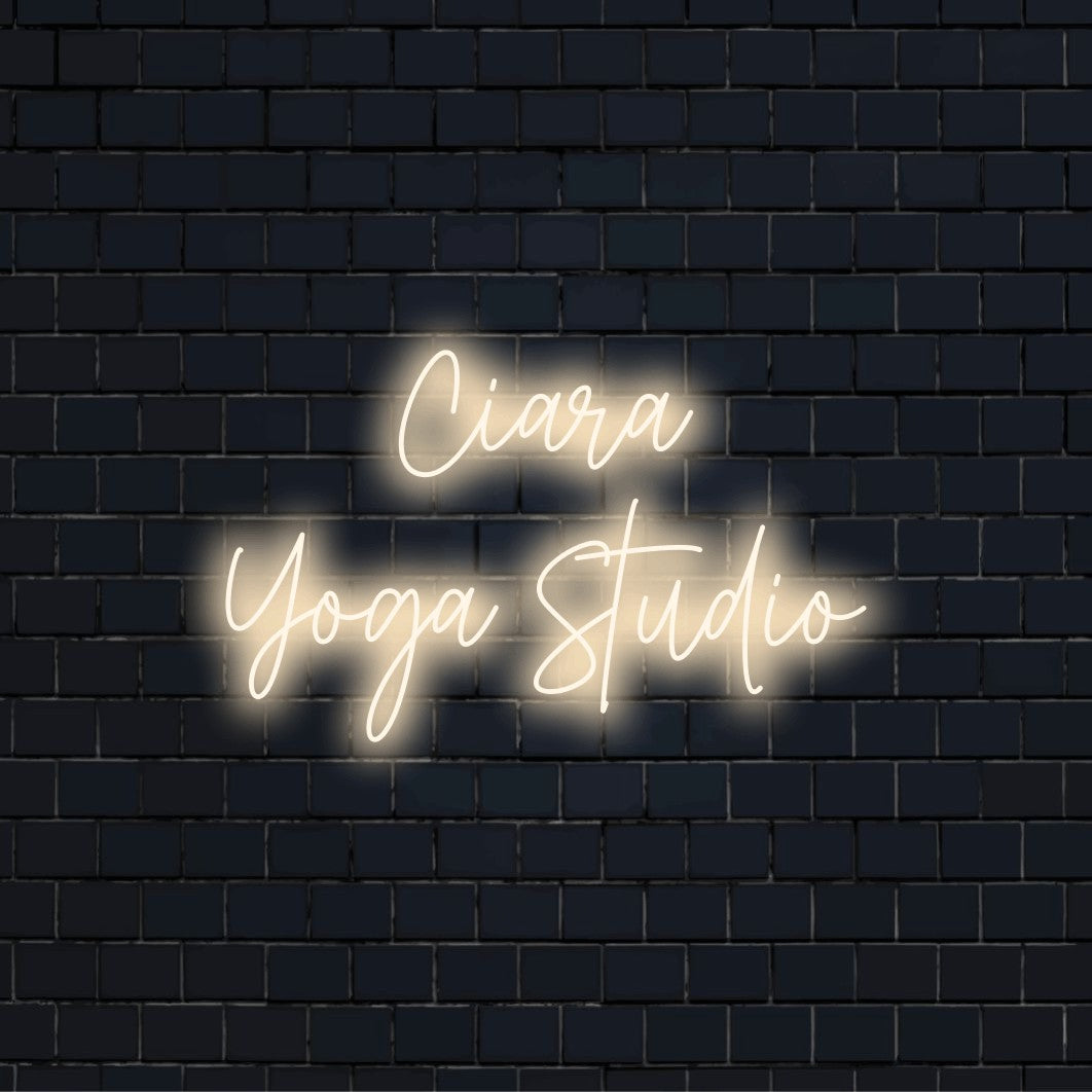 Ciara Yoga Studio Custom Name Neon Sign, bright neon lettering on black brick background