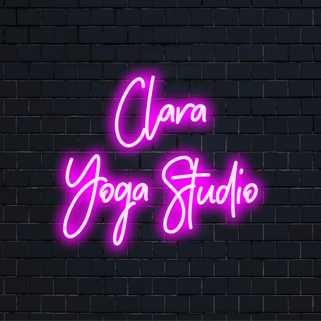 Clara Yoga Studio Personalized Neon Light with bright neon glow on dark brick background